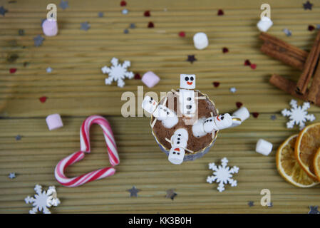 Winter essen und trinken Fotografie Bild mit heißer Schokolade Tasse mit Happy snowman von Marshmallows mit roten Herzen im Hintergrund gefüllt Stockfoto