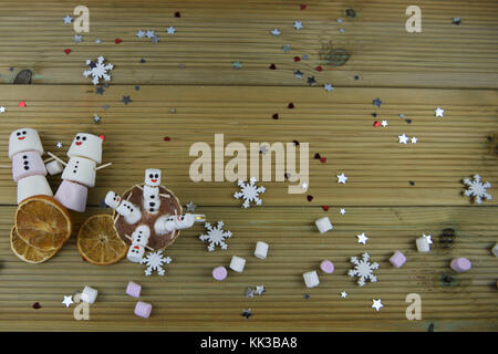 Winter essen und trinken Fotografie Bild mit heißer Schokolade Tasse mit Happy snowman von Marshmallows mit roten Herzen im Hintergrund gefüllt Stockfoto