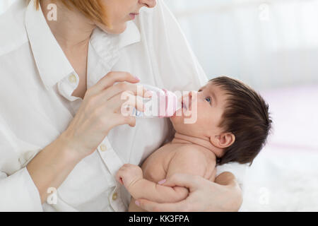 Mutter halten und Wasser zu Baby von der Flasche Stockfoto