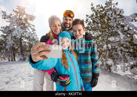 Fröhliche Eltern mit Kindern unter selfie auf Skifahren Stockfoto