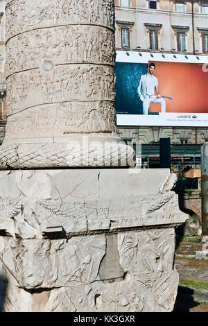 Lacoste Werbetafel auf einem Baugerüst im Trajan Market Forum. Trajans Säule aus der Nähe. Rom, Italien, Europa. Neuer und alter Kontrast. Stockfoto