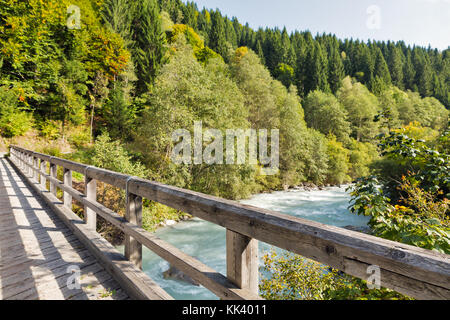 Hölzerne Brücke über Fluss Gail mit der alpinen Landschaft im westlichen Kärnten, Österreich. Stockfoto