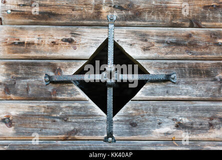 Alte Wassermühle Fenster aus Holz mit Metall Kreuz closeup im westlichen Kärnten geschlossen, Österreich Stockfoto