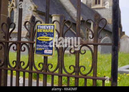 Schild "Diebe Vorsicht - smartwater - Forensische Systeme zu Metalle" schützen, Llanrhystud Kirche, Wales, Großbritannien Stockfoto