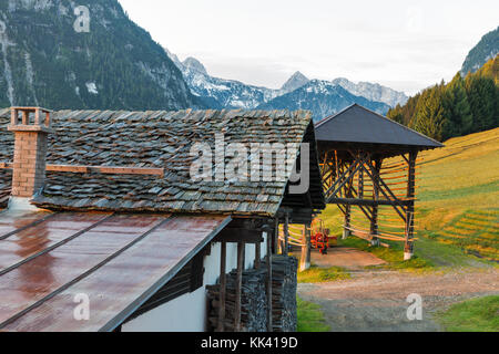 Alpen Dorf sunrise Landschaft und Holzschuppen mit Traktor. Nostra, westlichen Kärnten in Österreich. Stockfoto