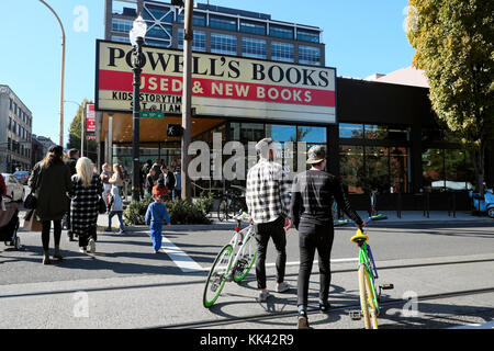 Außenansicht der Männer mit den Fahrrädern, die Überquerung der Straße außerhalb Powell's Books berühmten Book Store in Portland Oregon USA KATHY DEWITT Stockfoto