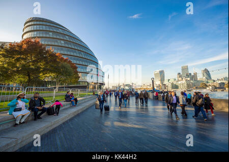 London - 31. Oktober 2016: Besucher nutzen milden Herbst Nachmittag auf dem Südufer der Themse Riverside vor der City Hall. Stockfoto