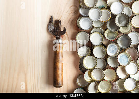 Vintage öffner in der Nähe der Deckel von Bier, auf einer hölzernen Hintergrund, Platz für Text Stockfoto