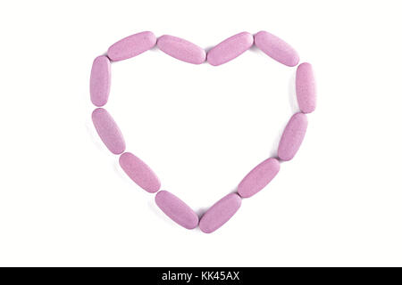 Tabletten in Form von Herzen verstreut sind, das Konzept der Behandlung von Herzkrankheiten, isoliert Stockfoto