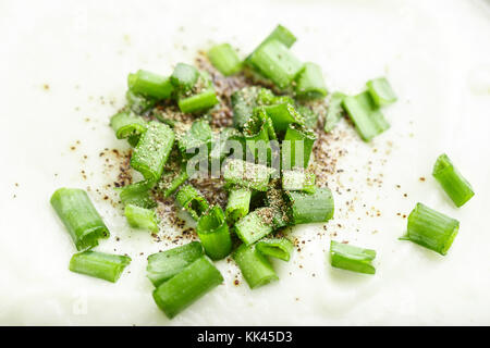 Creme Suppe in einer Platte Draufsicht, Suppe mit grünen Zwiebeln eingerichtet Stockfoto