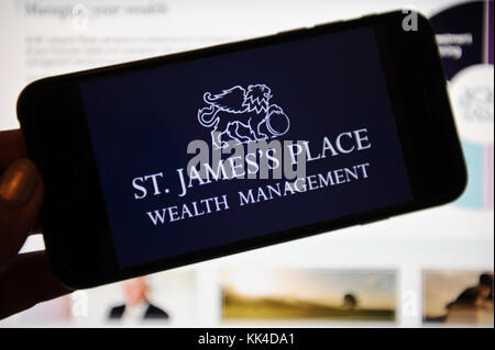St. James's Place Wealth Management Logo auf einem Telefon und Computer-Bildschirm Stockfoto
