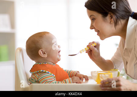 Mutter Löffel füttern Sie Ihr Kind Junge Stockfoto