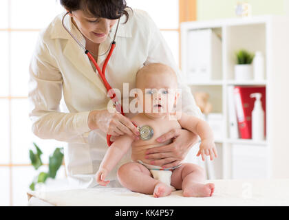 Frau Kinderarzt Prüfung von baby boy mit Stethoskop Stockfoto
