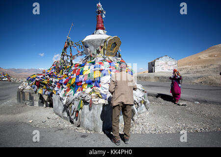 Die Menschen in der traditionellen Kleidung bei Tanglangla Pass in den Himalaya entlang der Autobahn Leh-Manali, Ladakh, Jammu und Kaschmir, Indien zu beten. Stockfoto