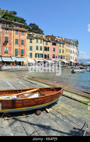 Italien, Ligurien: Portofino. Holz- Boot im Trockendock und Segelboote im Hafen des kleinen Dorfes mit bunten Häusern geschützt in einer Bucht Stockfoto