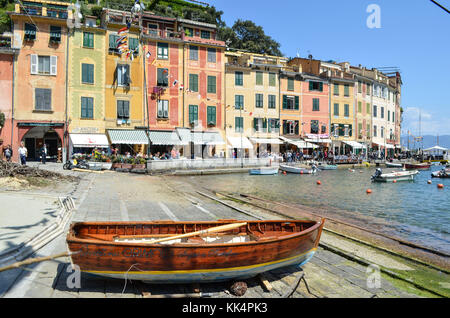 Italien, Ligurien: Portofino. Holz- Boot im Trockendock und Segelboote im Hafen des kleinen Dorfes mit bunten Häusern geschützt in einer Bucht Stockfoto