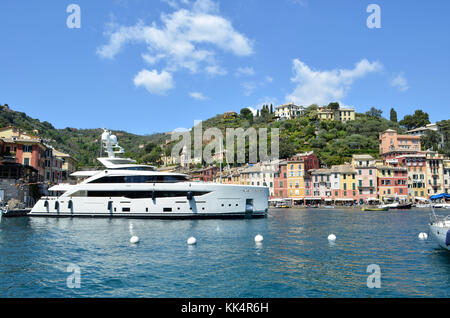 Italien, Ligurien: Portofino. Überblick mit einer Yacht und Segelboote im Hafen des kleinen Dorfes mit bunten Häusern geschützt in einer Bucht Stockfoto