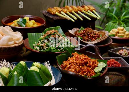 Balinesische Buffet. sortiert der balinesischen Beilagen serviert Buffet gestaltet; auf einem Tisch, gesäumt mit traditionellen Balinesischen seseh Gewebe aus Spinnstoffen. Stockfoto