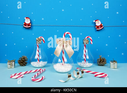 Weihnachten Zusammensetzung mit dem Weihnachtsmann, Geschenke und Zuckerstangen auf blauem Hintergrund. Stockfoto