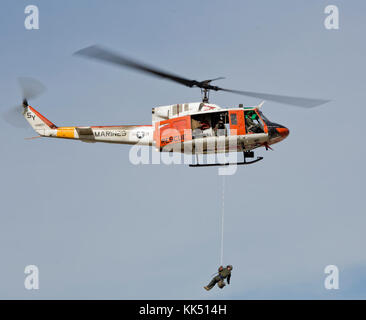 Ein HH1-N 'Huey' Overhead ein zeremonielles Schwert während der jährlichen Kuchen-ausschnitt Zeremonie an der Marine Corps Air Station Yuma, Ariz., Nov. 8, 2017 zu liefern fliegt. Die Lieferung der Schwert von einem US-Nacycorpsman zu einem US-Marine bedeutet die Bindung zwischen der Navy und Marine Corps. (U.S. Marine Corps Foto von Cpl. Christian Cachola) Stockfoto