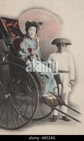 Farbiges Studio-Porträt einer jungen asiatischen Frau in einer Ricksäge, mit Kimono und Sonnenschirm, mit Fahrer posiert, weiß gekleidet und mit Hut, 1920. Aus der New York Public Library. Stockfoto