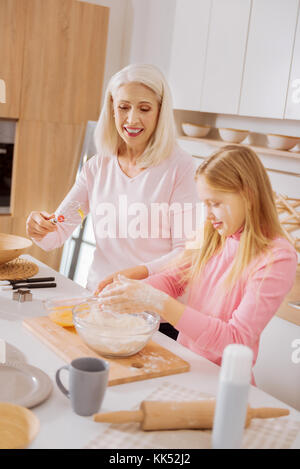 Spaß. freudige glücklich nettes Mädchen kochen Essen und Spaß beim mit Mehl bedeckt sein. Stockfoto