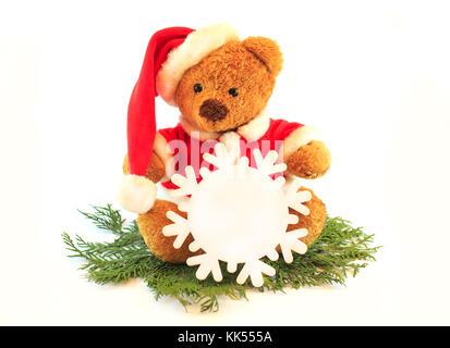 Spielzeug Teddybär mit Weihnachtsmütze, auf weißem Hintergrund mit Schneeflocken in den Händen isoliert Stockfoto