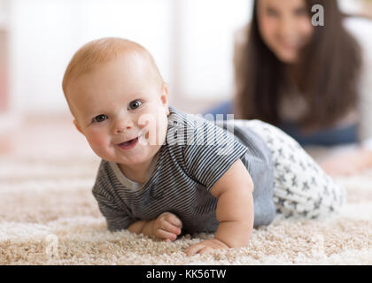 Mutter spielt mit Kriechen auf dem Boden baby Stockfoto