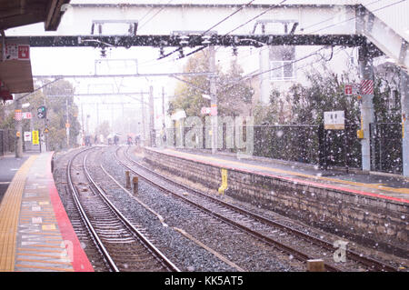 Gewundene Bahn ein Zug in Japan, während schwer mitten im Winter schneit Stockfoto