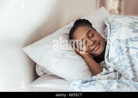 Junge afrikanische Frau fest schlafend in ihrem Bett zu Hause. Stockfoto