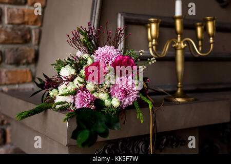 Braun dekorativer Kamin mit bunten Blumen und Kerzen Stockfoto