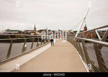 Fußgänger überqueren die berühmte Friedensbrücke über den Fluss Foyle in Londonderry City in Nordirland Stockfoto