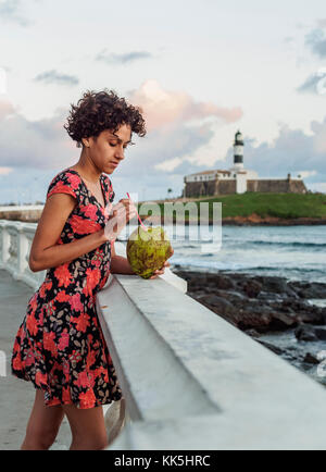 Brasilianische Modell Kokosnuss Wasser trinken, Barra, Salvador, Bundesstaat Bahia, Brasilien Stockfoto