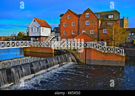 Diese hübsche Riverside View von Tewkesbury Wassermühle & Wehr am Fluss Avon hat einen Blick von Tewkesbury Abbey im Hintergrund. Stockfoto