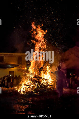 Die Menschen feiern St John's Eve um ein Lagerfeuer in einem griechischen Dorf. Stockfoto