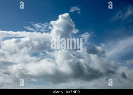 Dramatische Wolken im Sonnenlicht gegen den blauen Himmel. Stockfoto