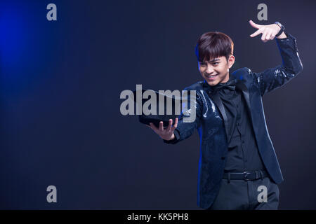 Junge chinesische Zauberer zugesehen Magic trick Stockfoto