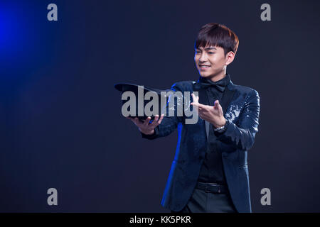 Junge chinesische Zauberer zugesehen Magic trick Stockfoto