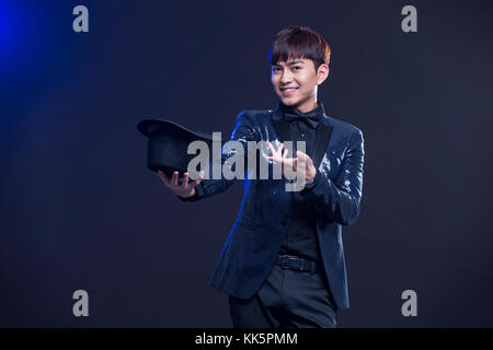 Junge chinesische Zauberer zugesehen Magic trick Stockfoto