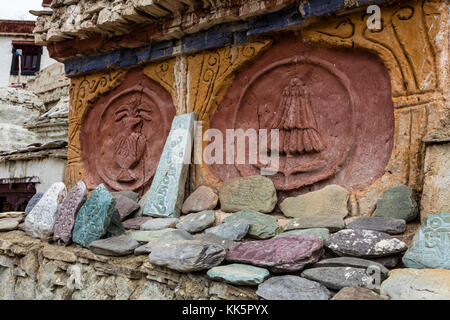 Buddhistische Mani Steine geschnitzt mit Gebete umgeben einen Stupa in LAMAYURU KLOSTER von NAROPA - LADAKH, Indien gegründet. Stockfoto