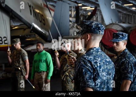 Marines üben Schwert- und Führungsbewegungen in der Hangarbucht des Flugzeugträgers USS Theodore Roosevelt (CVN 71). Theodore Roosevelt wird zur Unterstützung von Seeverkehrssicherheitsoperationen und der Zusammenarbeit im Bereich der Theatersicherheit eingesetzt. (USA Navy Foto von Machinist Mate 3rd Class Andrew Langholf/veröffentlicht) Stockfoto