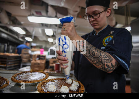 INDISCHER OZEAN (Nov 23, 2017) Culinary Specialist 2nd Class Sarah Server, von Excelsior Springs, Mississippi, fügt Kürbiskuchen Schlagsahne zur Vorbereitung auf das Thanksgiving Dinner in der Galeere des Flugzeugträgers USS Theodore Roosevelt (CVN 71) hinzu. Theodore Roosevelt wird zur Unterstützung von Seeverkehrssicherheitsoperationen und der Zusammenarbeit im Bereich der Theatersicherheit eingesetzt. (USA Navy Foto von Mass Communication Specialist 3rd Class Jimmi Lee Bruner/veröffentlicht Stockfoto