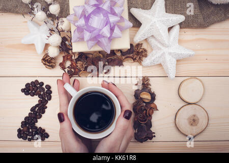 2018 Inschrift von Kaffeebohnen und Hände halten einer Tasse Kaffee Stockfoto