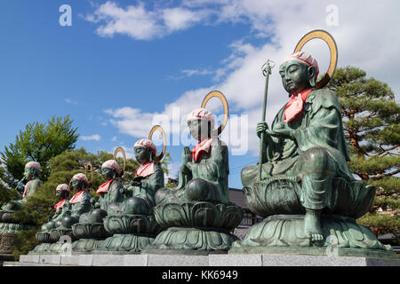 Nagano, Japan, Juni 3, 2017: Sechs bronze Buddha Statuen mit red Bibs und Motorhauben rokujizo genannt, oder 6 jizo, Zenkoji Tempel, Nagano
