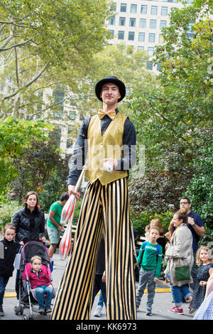 Ein Stelzenläufer Adam Benson auf einer Straßenmesse im Madison Park, New York City. Stockfoto