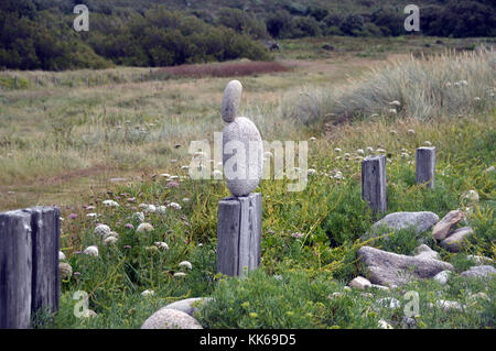 Kleiner Stein ausgeglichen auf großen Stein auf einem alten Fencepost auf der Insel Bryher, Isles of Scilly, Cornwall, Großbritannien. Stockfoto