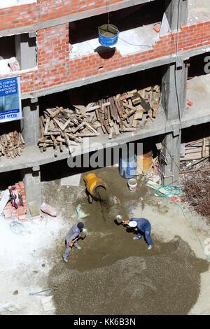 Arbeitnehmer laden Kies in den Betonmischer auf Baustelle, La Paz, Bolivien Stockfoto