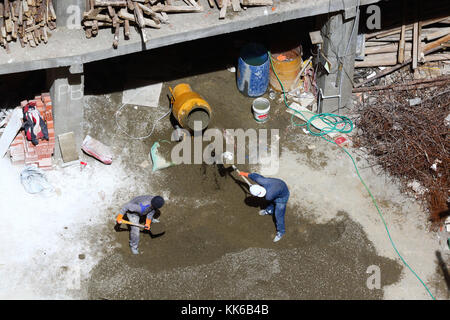 Arbeitnehmer laden Kies in den Betonmischer auf Baustelle, La Paz, Bolivien Stockfoto