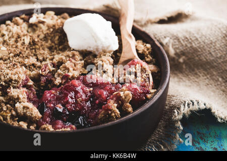 Birne und Berry zerfällt, serviert mit Sahne im rustikalen Keramik Schüssel Stockfoto