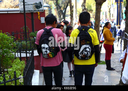 Jugendliche tragen Rucksäcke mit Gesichtern von Jimi Hendrix (L) und Kurt Cobain (R) auf der Straße, La Paz, Bolivien Stockfoto